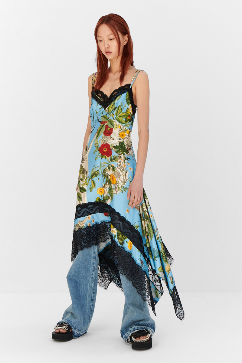 MONSE Resort 2024 Collection Vogue image of model wearing a long floral slip dress with jeans