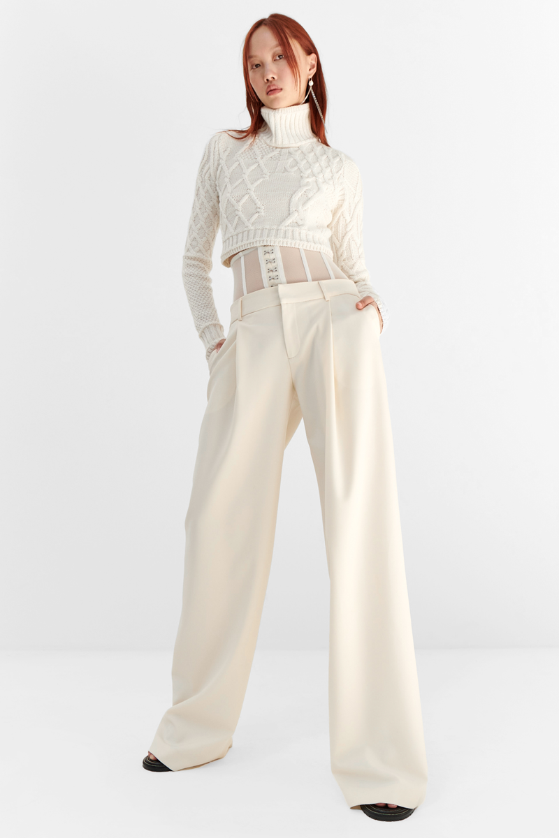 MONSE Resort 2024 Collection Vogue image of model wearing a white turtleneck sweater with white trousers