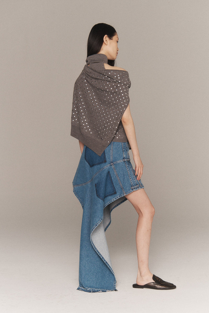 MONSE Resort 2026 collection lookbook image of a model wearing a gray shawl and denim dress on a plain background