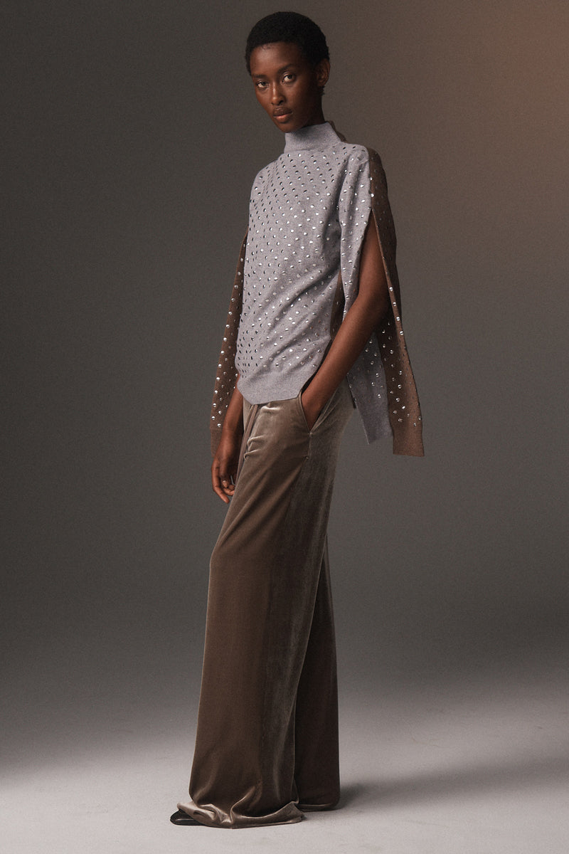 MONSE Resort 2026 collection lookbook image of a model wearing a gray turtleneck with a textured overlay and brown pants against a neutral background