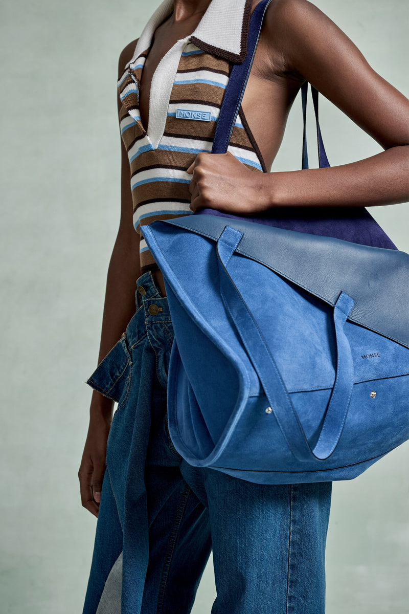 MONSE Spring 2026 Collection look 21 person holding a blue bag with a neutral background
