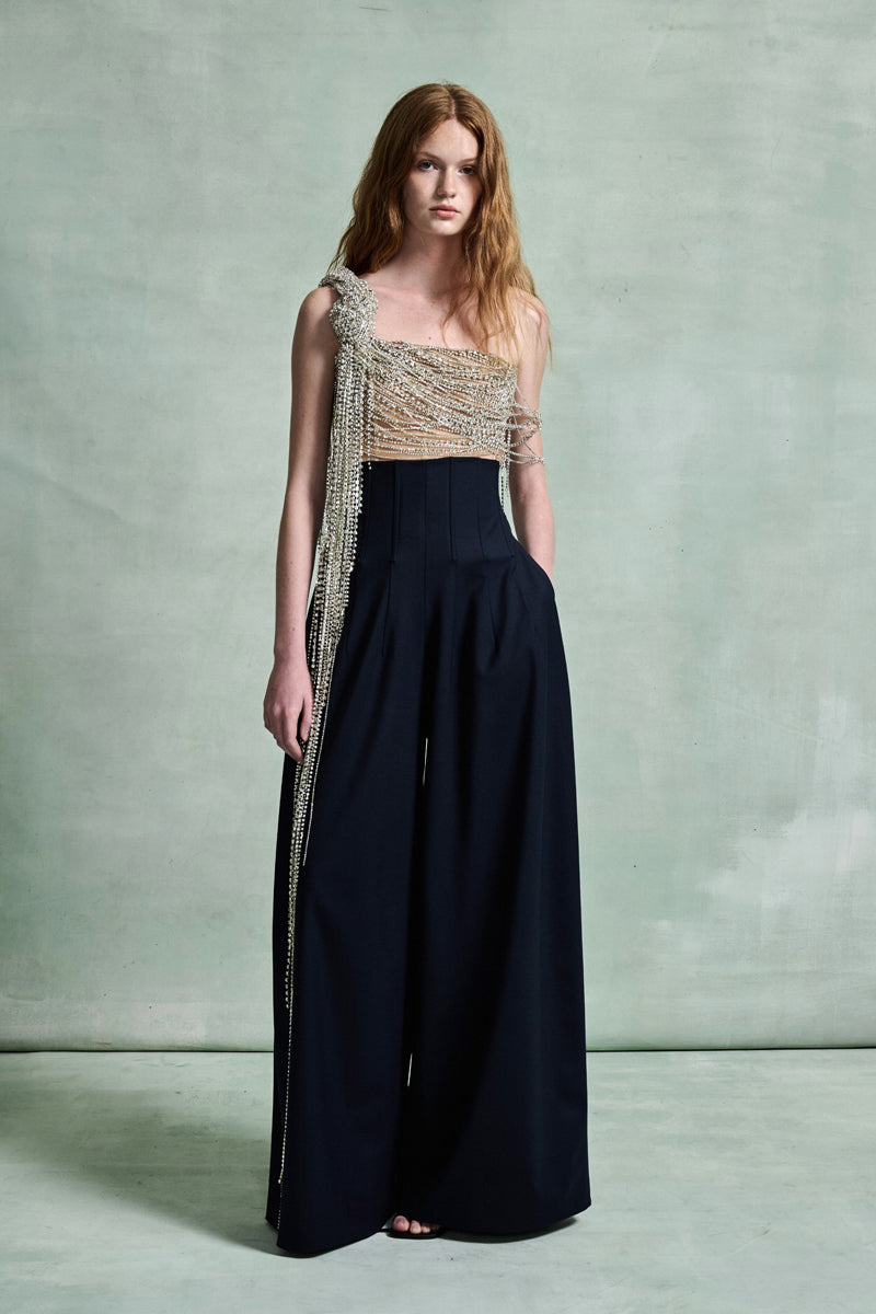 MONSE Spring 2026 Collection look 4 woman wearing a black dress with a gold top against a plain background