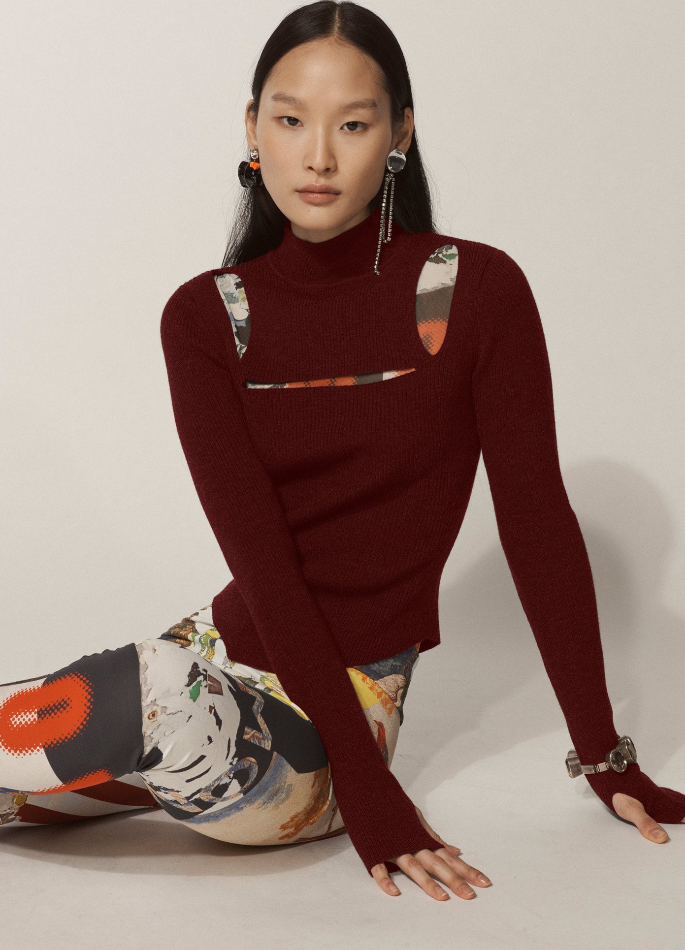 MONSE Slit Knit Top in Merlot on Asian Model Sitting Down Front View