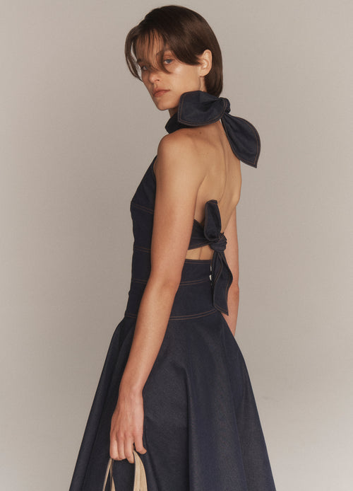 MONSE Back Bow Tie Midi Dress in dark indigo on model looking over shoulder side view