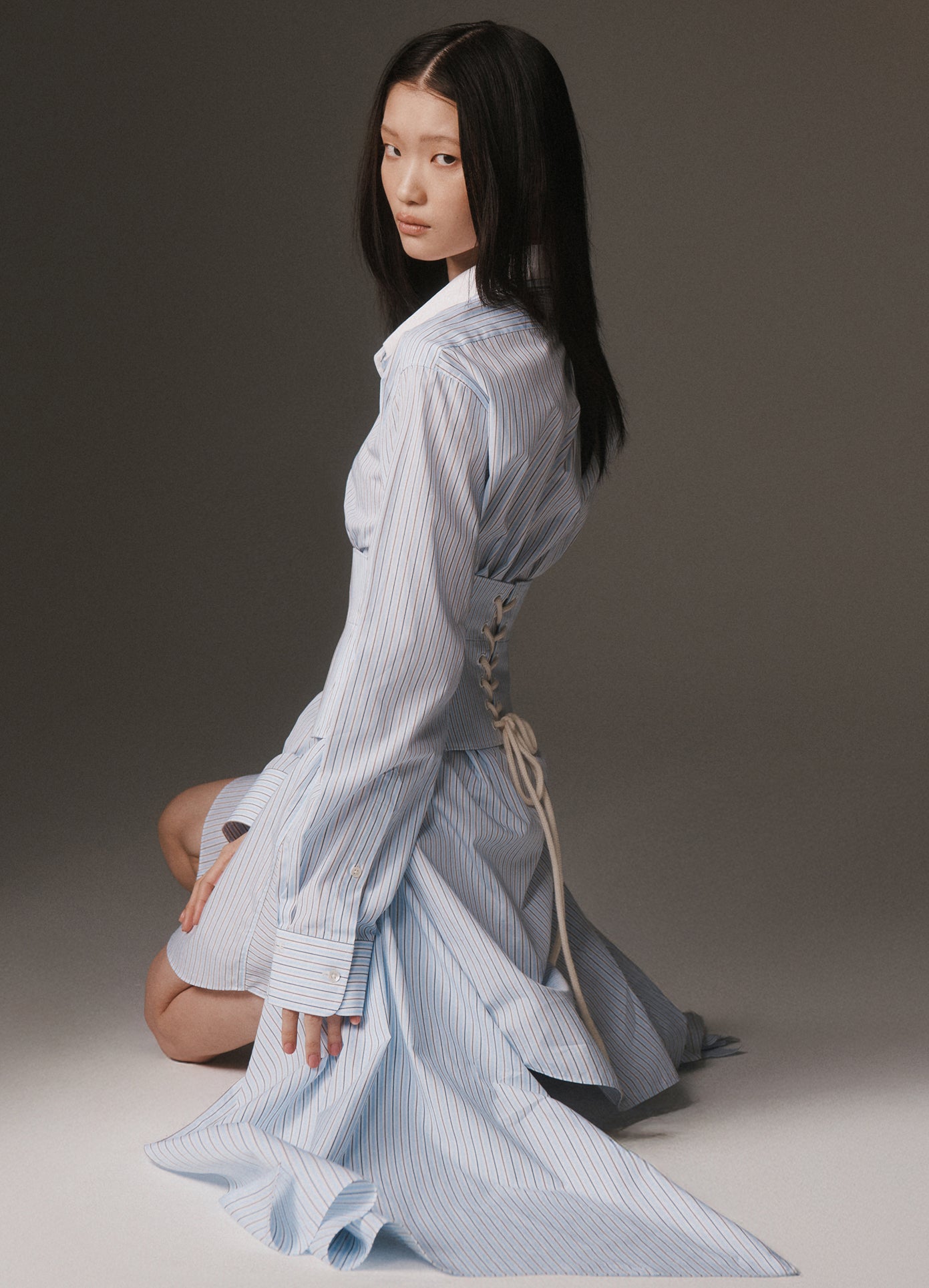 MONSE Corsetted Shirt Dress in blue multi on model sitting on floor