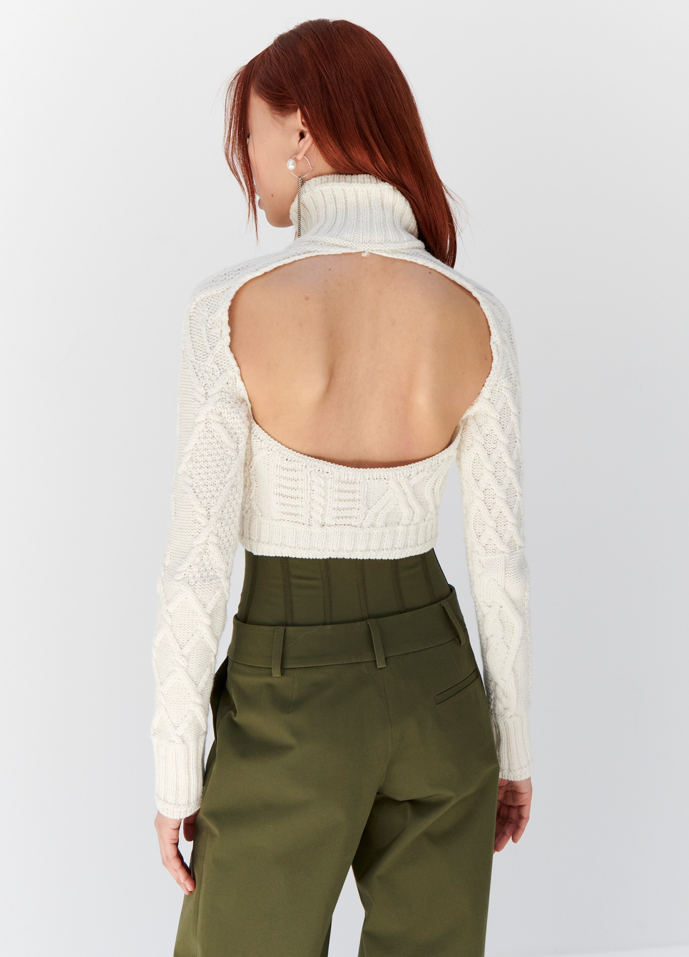 MONSE Cropped Cable Sweater in Ivory on model wearing green trousers back detail view