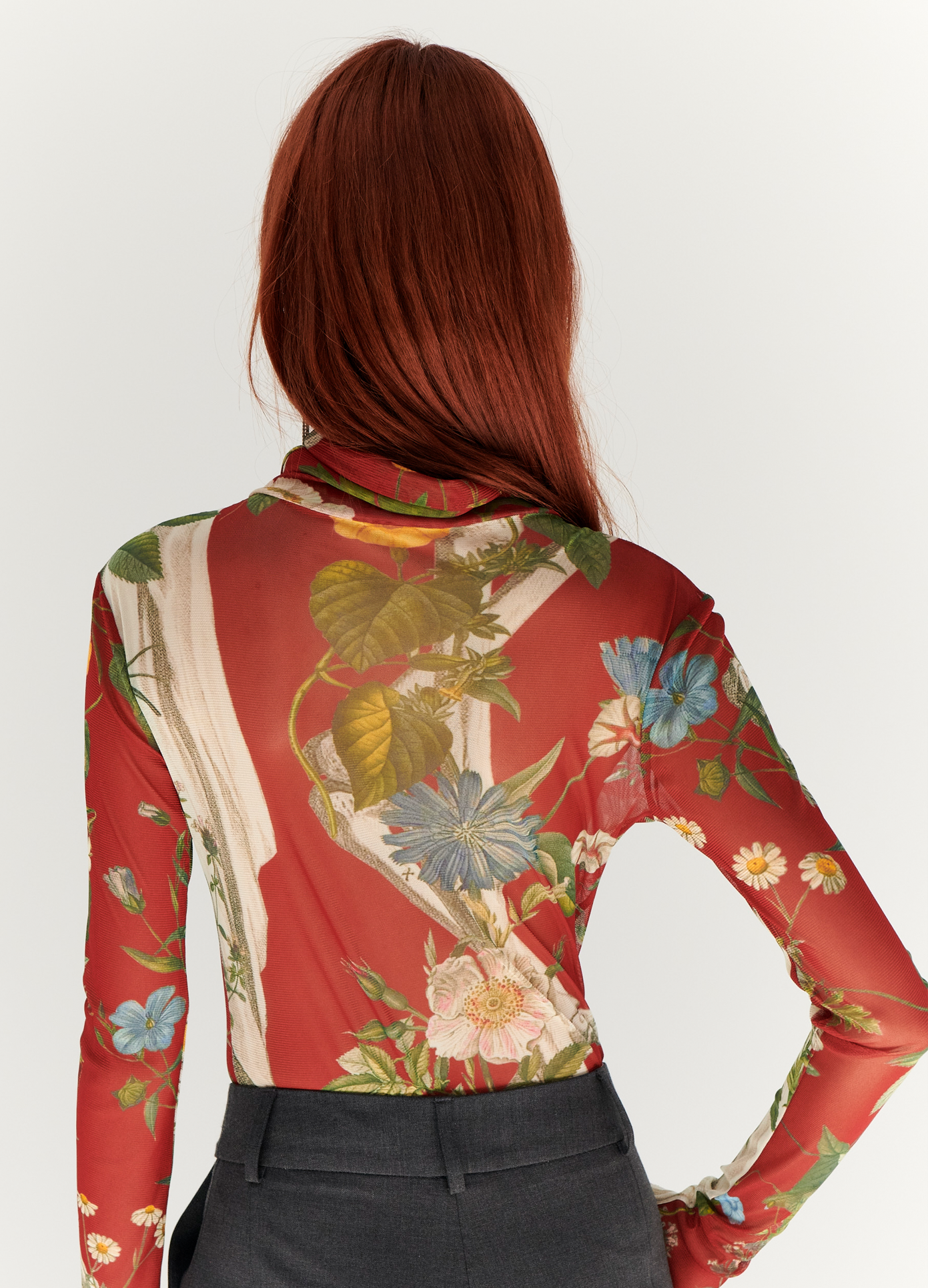 MONSE Floral Skeleton Print Mesh Turtleneck in Red Multi on model with hand in pocket back view
