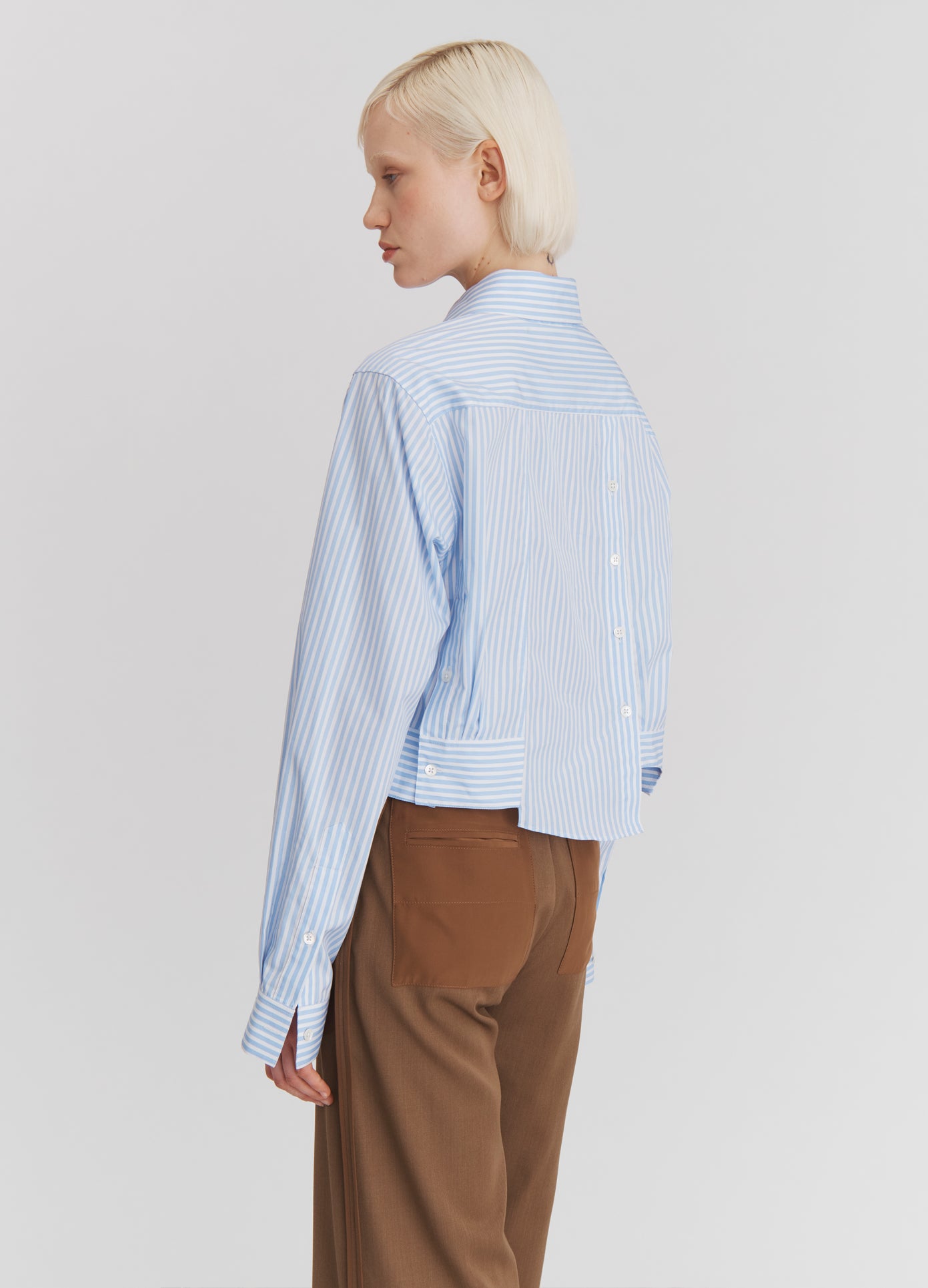 MONSE Paneled Cropped Shirt in Light Blue Stripe on model side back view