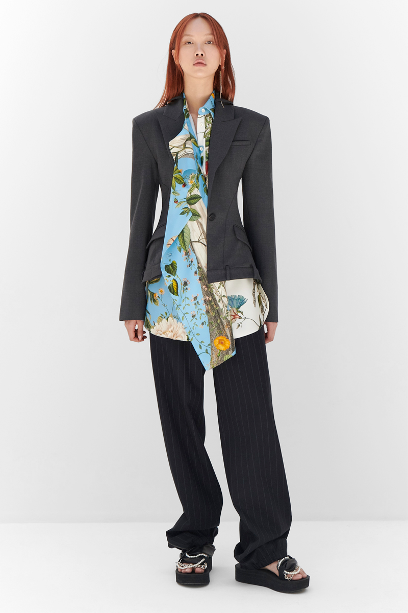 MONSE Resort 2024 Collection Vogue image of model wearing a deconstructed jacket with striped trousers