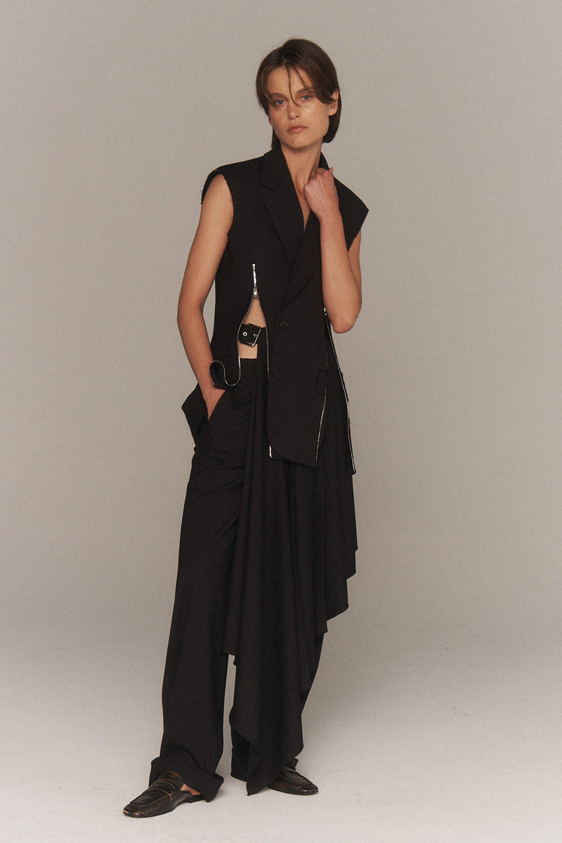 MONSE Resort 2026 collection lookbook image of a model wearing a black sleeveless top and pants with a vest on a plain background