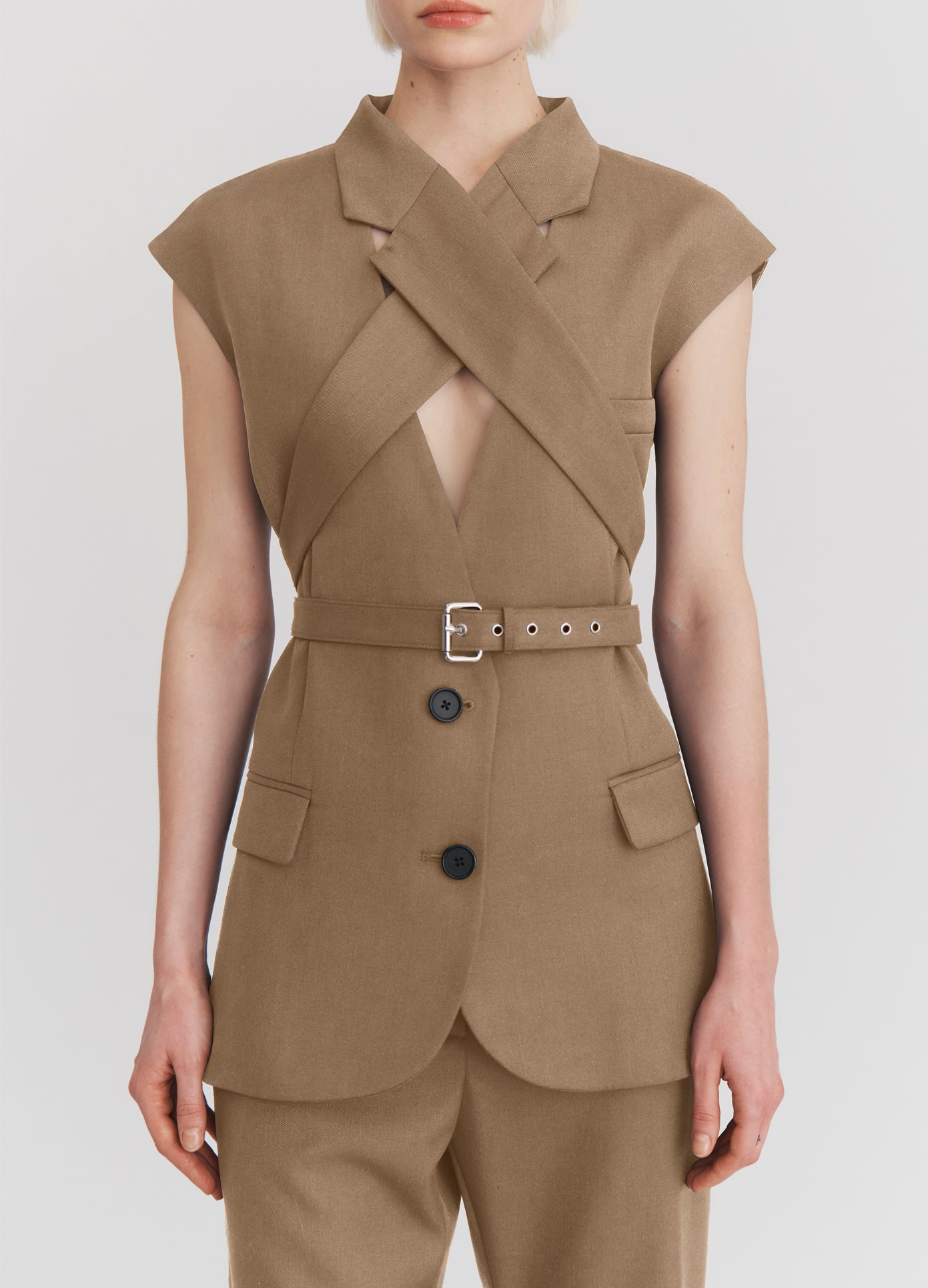 MONSE Sleeveless Criss Cross Jacket in beige on model front view