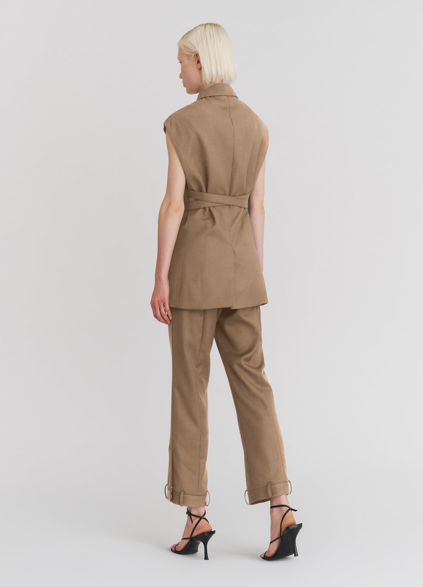 MONSE Sleeveless Criss Cross Jacket in beige on model full back view