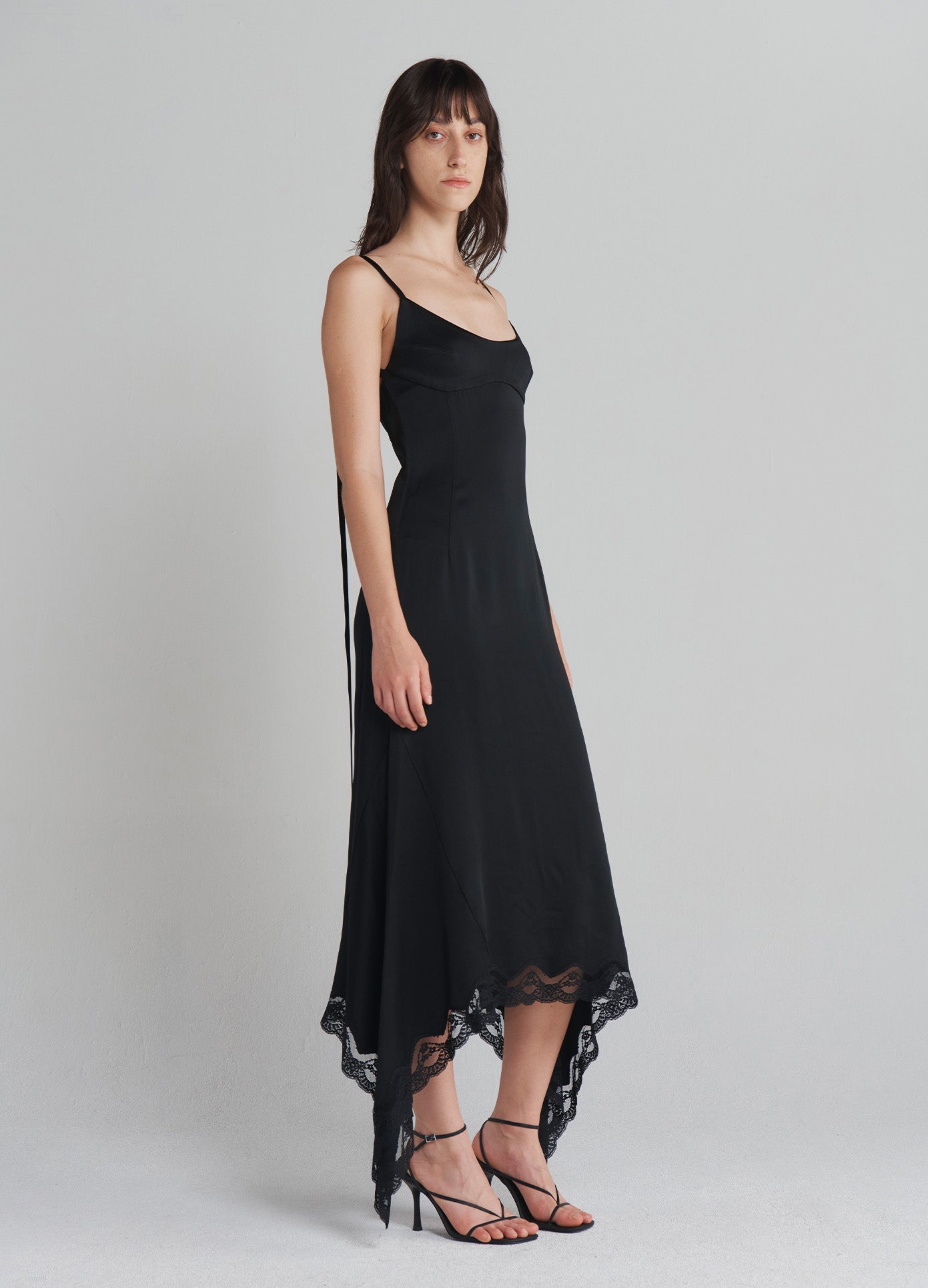 MONSE Slip Dress With Lace Hem in Black on model full side view