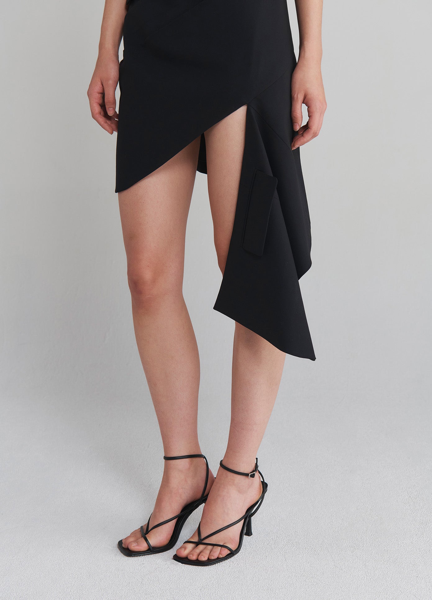 MONSE Tailored Asymmetrical Hem Dress in Black on model front bottom view