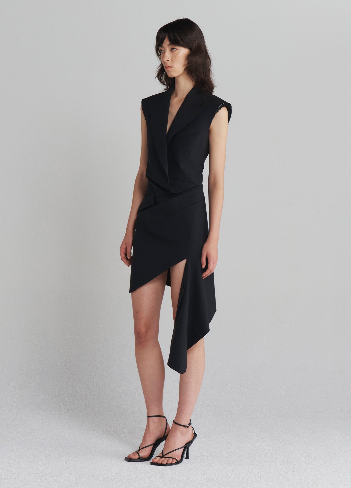 MONSE Tailored Asymmetrical Hem Dress in Black on model full side view