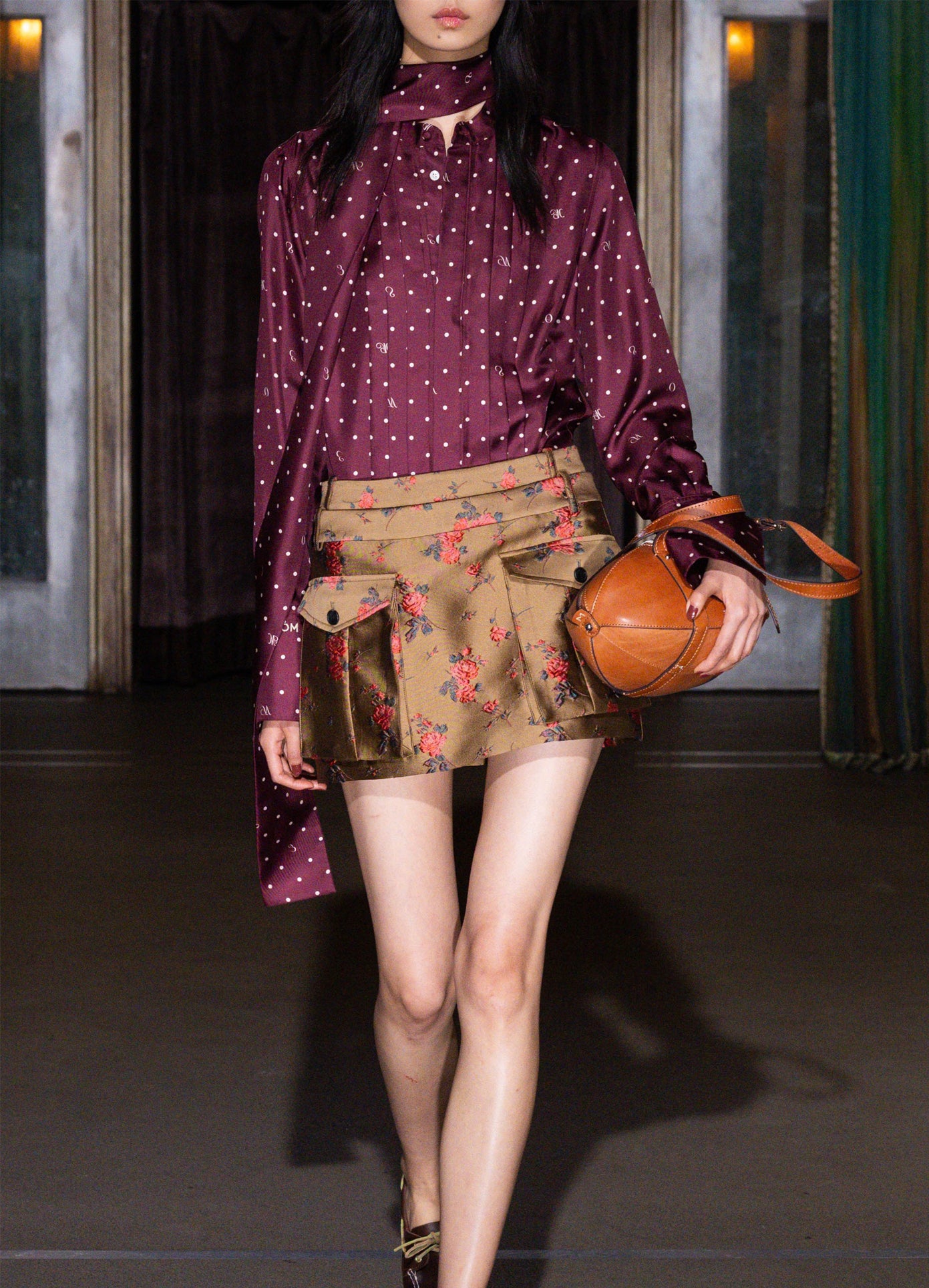 MONSE Tie Neck Cowl Back Blouse in burgundy on model walking runway