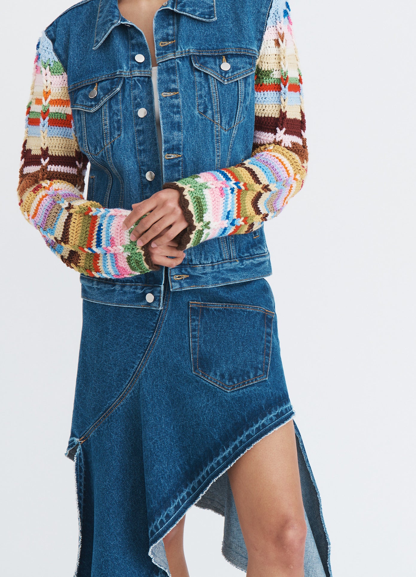MONSE Twisted Denim Skirt in indigo on model wearing multi colored knit sweater