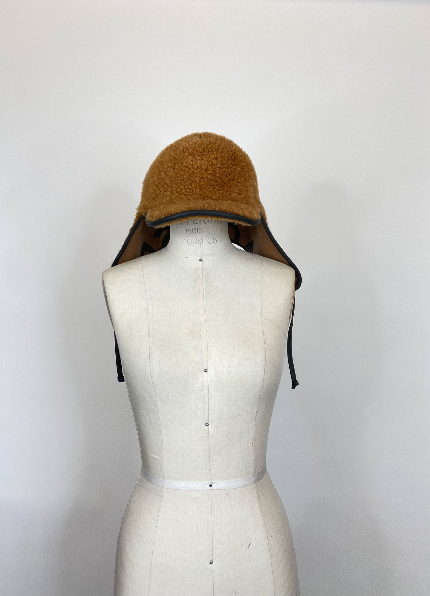 MONSE Cap with Ear Cover in Brown and Black on Mannequin Front View