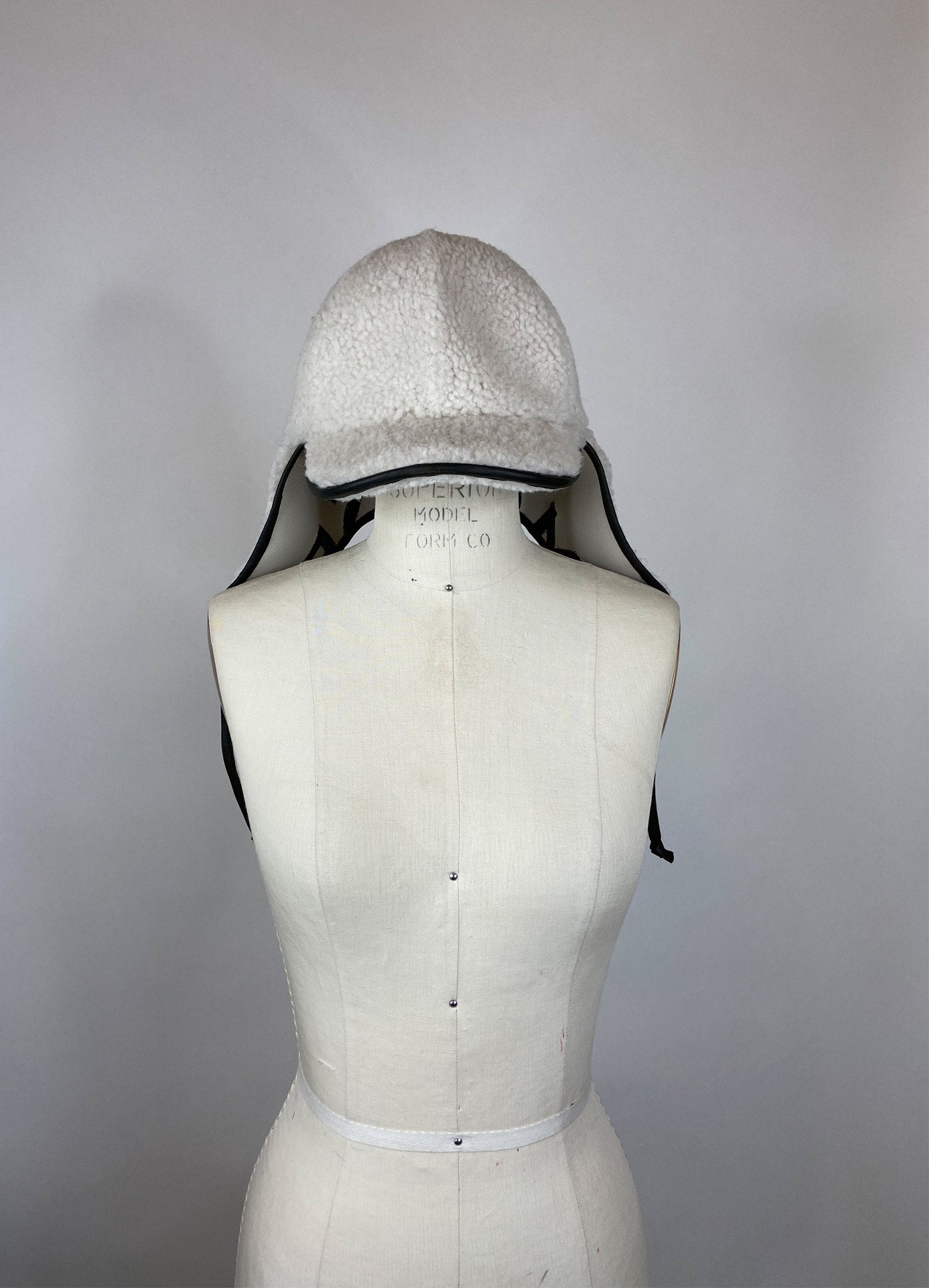 MONSE Cap with Ear Cover in Chalk and Olive on Mannequin Front View
