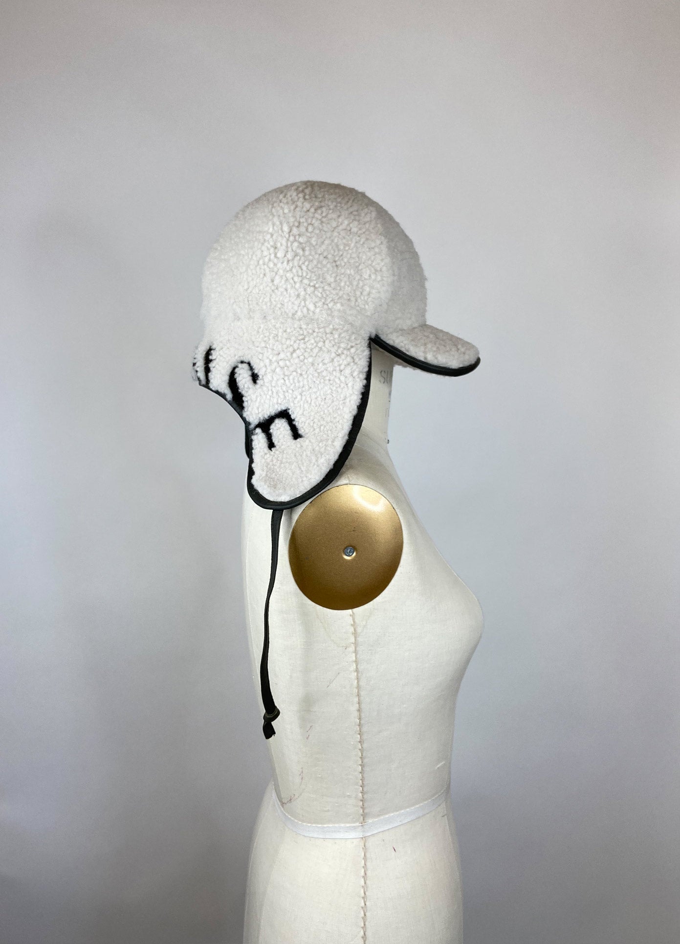 MONSE Cap with Ear Cover in Chalk and Olive on Mannequin Side View
