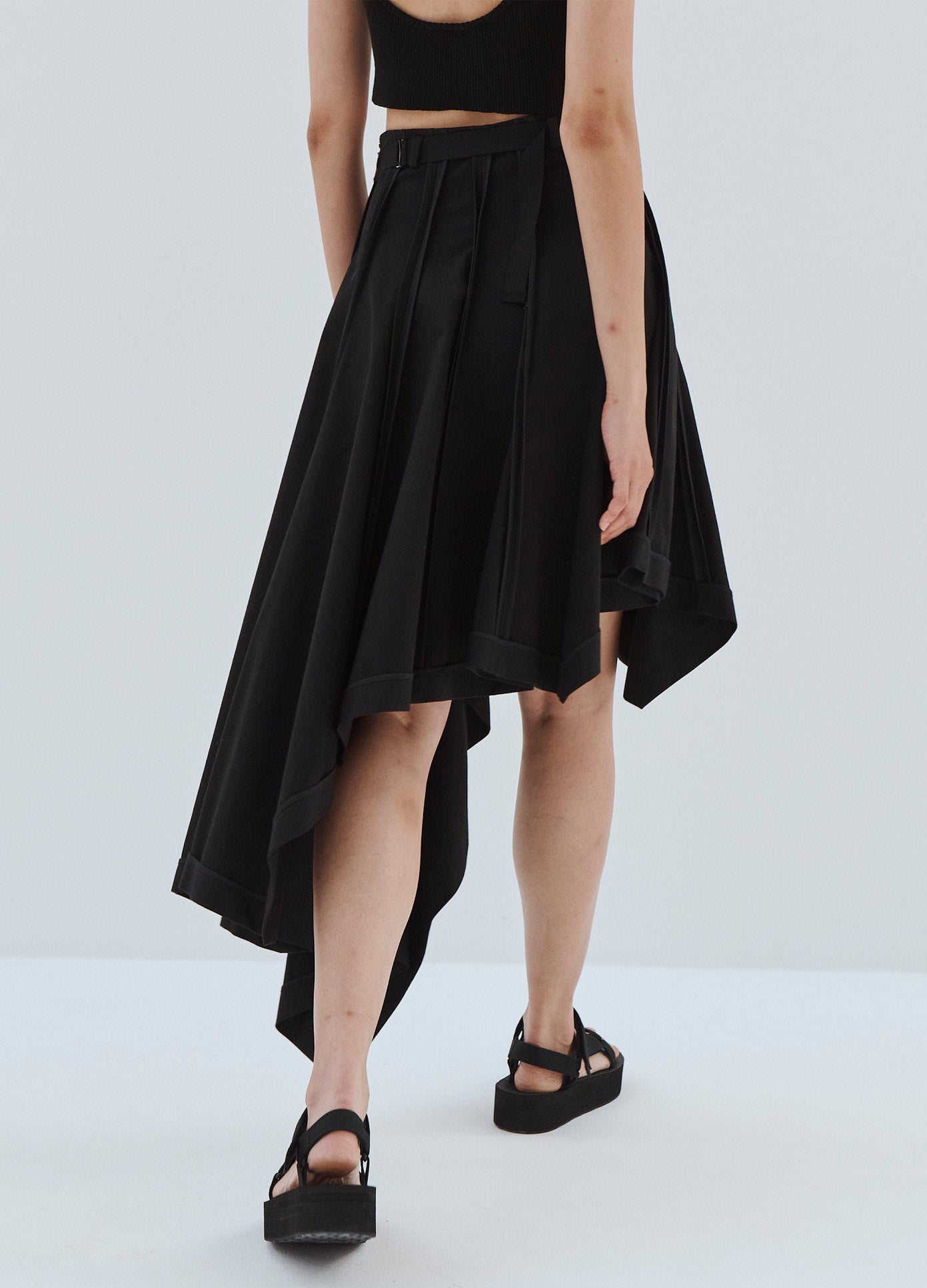 MONSE Laced Up Asymmetrical Hem Skirt in Black on Model Walking Back Detail View