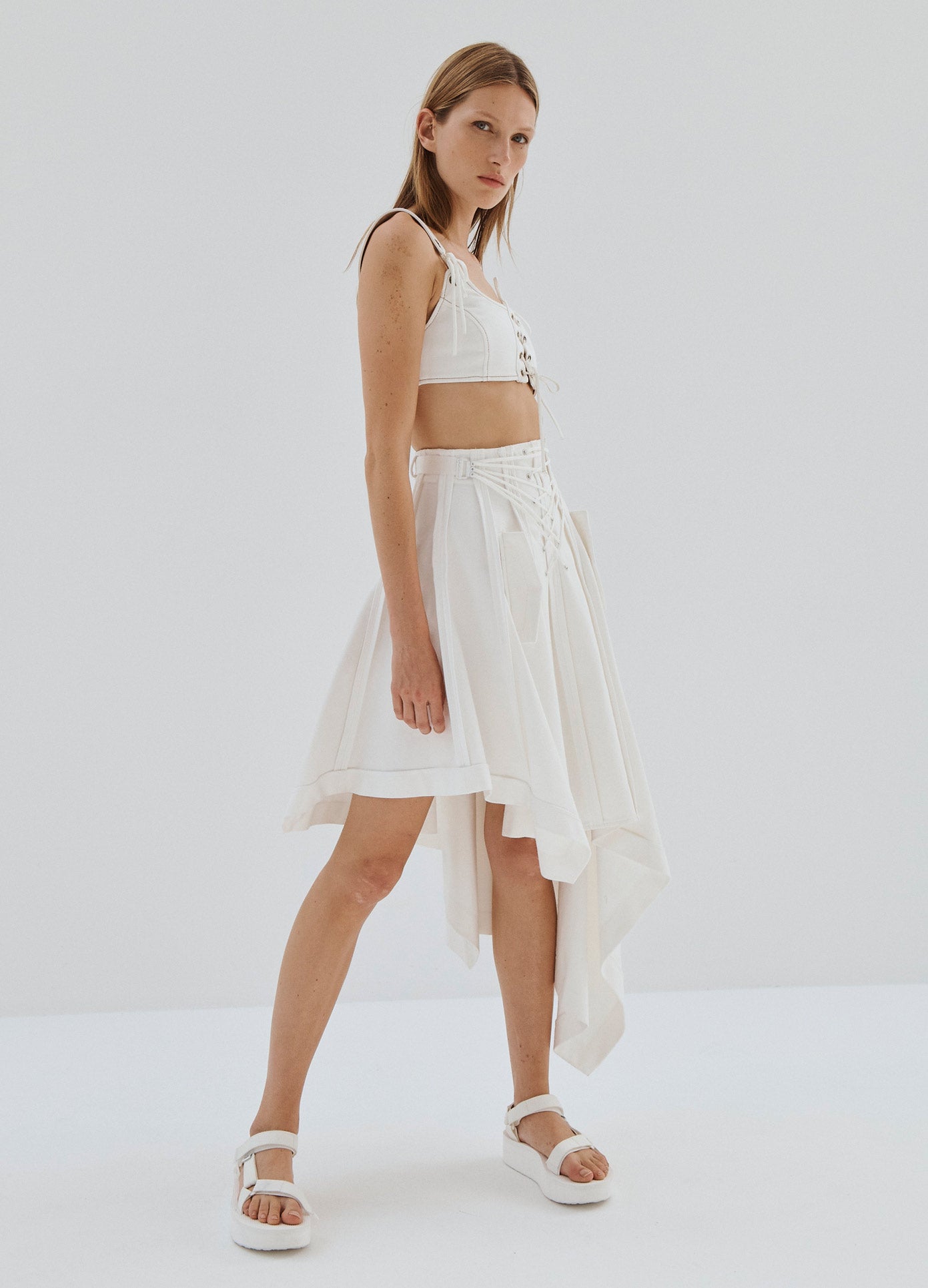 MONSE Laced Up Asymmetrical Hem Skirt in White on Model Full Side View