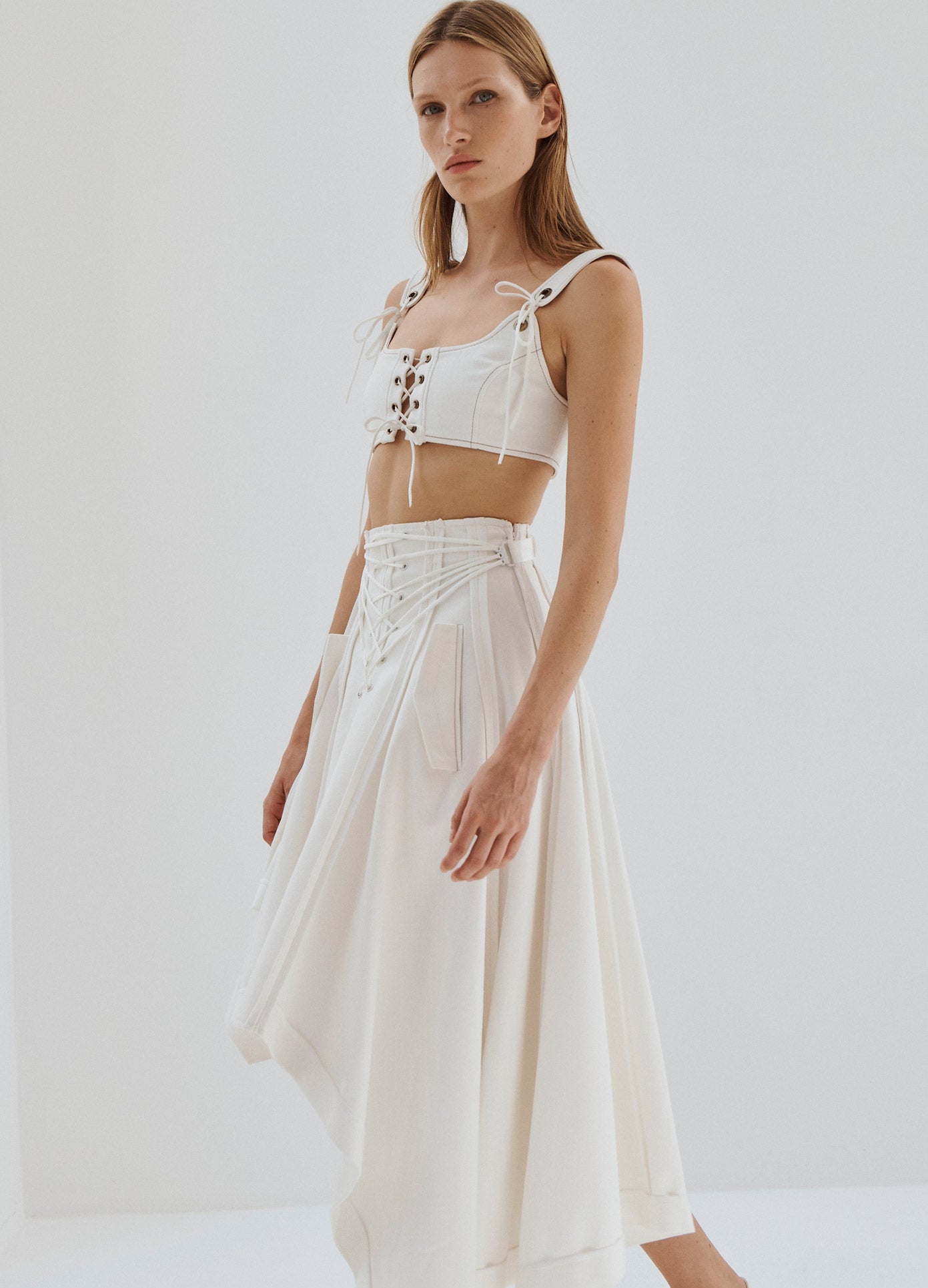 MONSE Laced Up Asymmetrical Hem Skirt in White on Model Side View