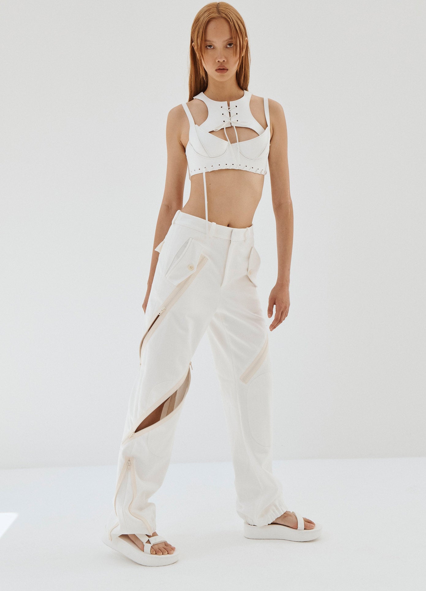 MONSE Zipper Detail Cargo Pants in White on Model Leaning Front View